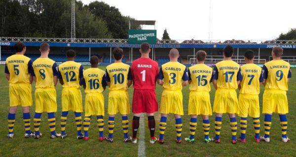 No primeiro plano, os "craques" do clube e ao fundo o patrocinador da ideia. Bela ação de marketing. 