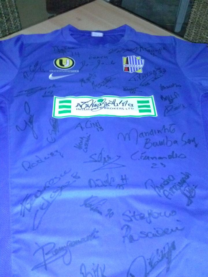 Camisa de seu novo clube, o Mosta FC. Abaixo da logo do patrocinador, a esquerda está a assinatura de Mandinho. 